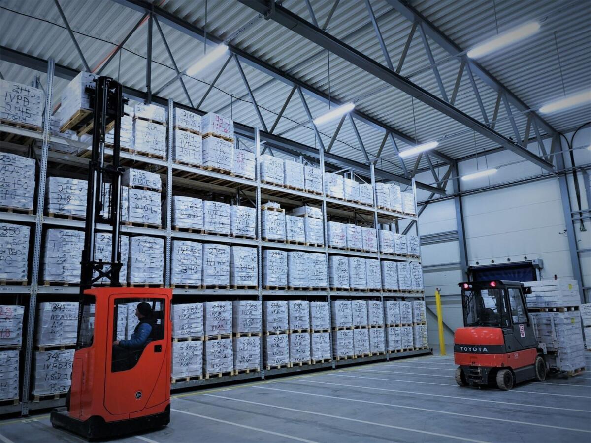 Truck mellom reolene i fryselageret, med paller stablet i flere høyder